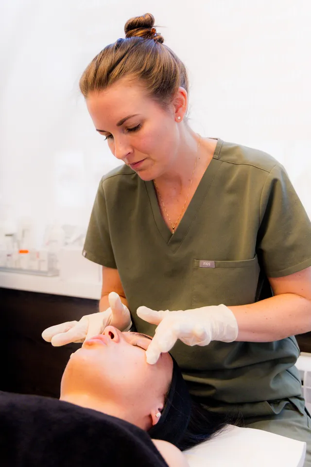 Medical aesthetician performing a targeted MediFacial treatment on a client's face